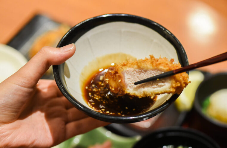 すり胡麻ソースにとんかつをくぐらせる