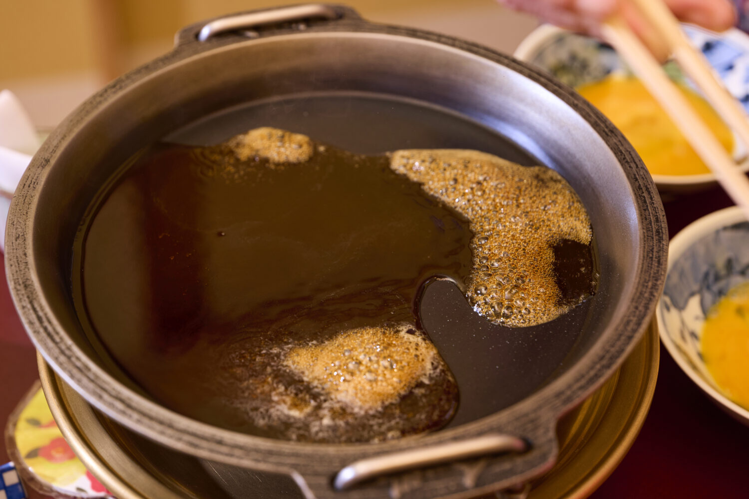 まずは前もって牛脂をひいておいた鍋を中火で温めたら、割り下を投入。中央からやさしく注ぎ、鍋の底が半分隠れるぐらいの量を目安にします。