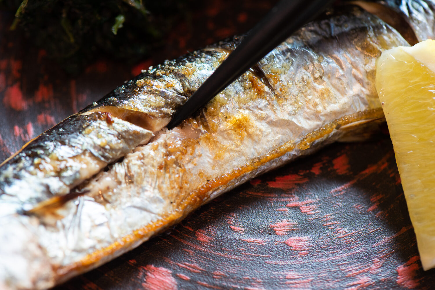秋刀魚は、腹びれの付け根から背骨に沿って箸で切れ目を入れていきます
