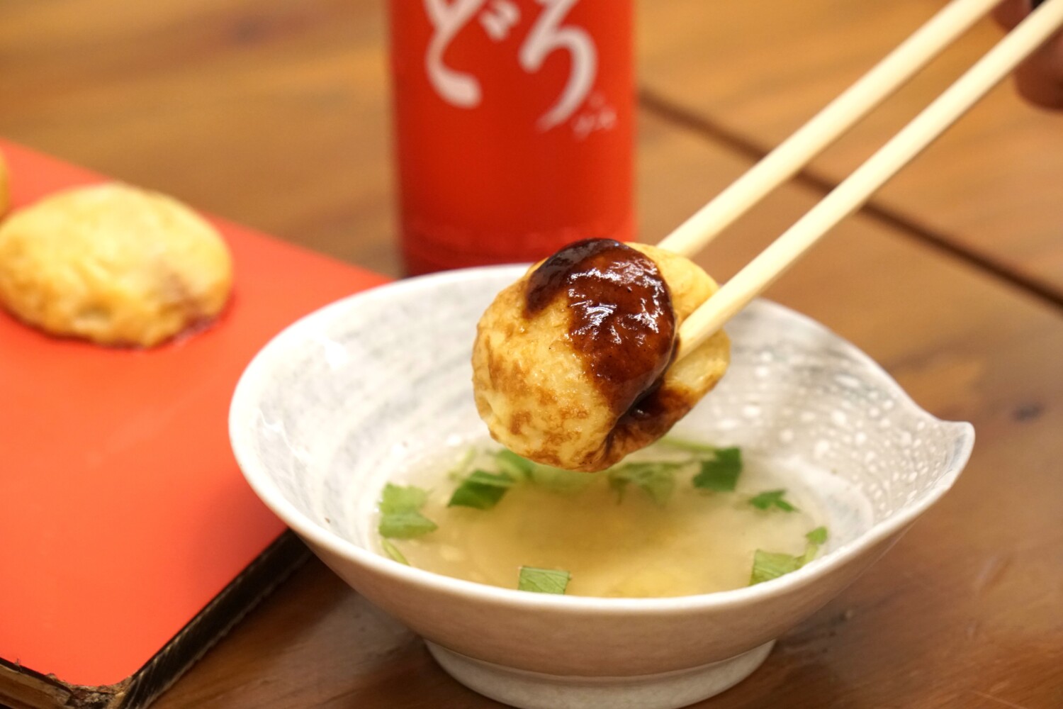 ソースをかけた状態の明石焼きを、だし汁につけて食べます。